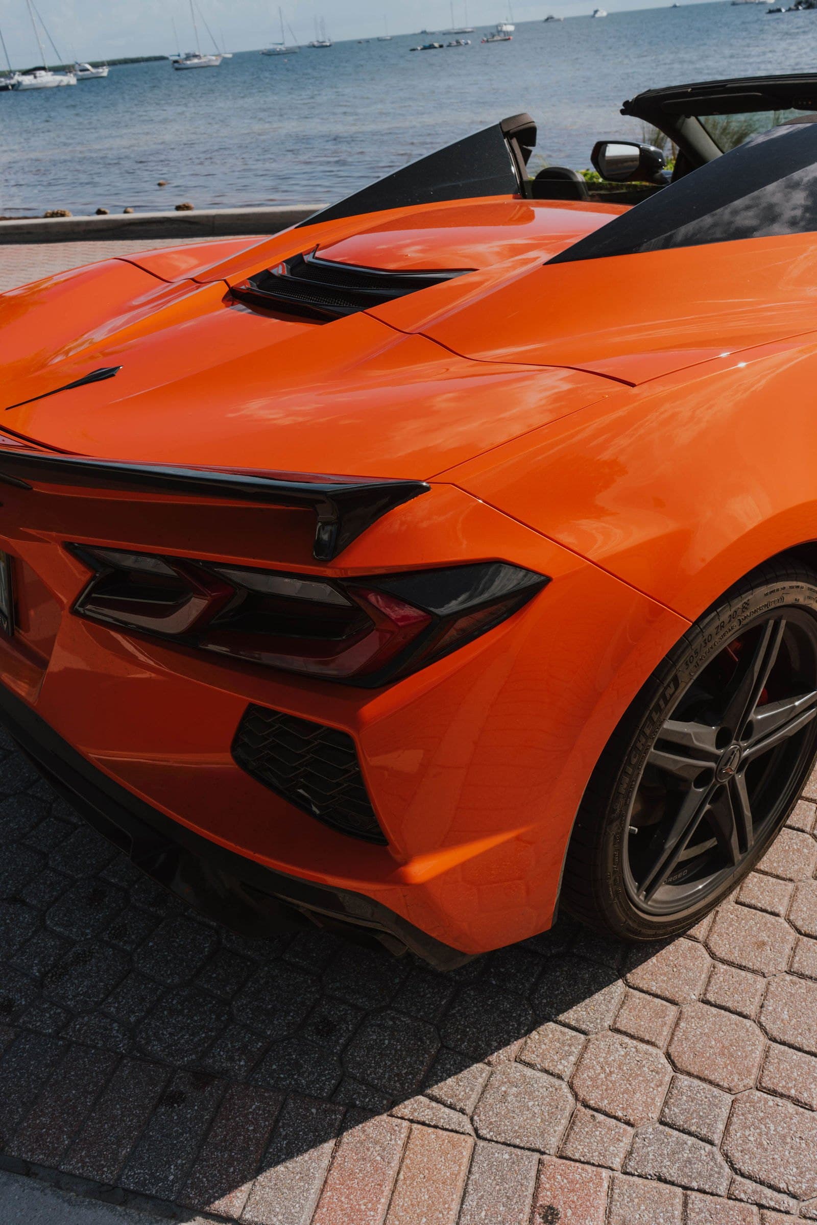 Rear haunch and taillight of an orange Corvette C8
