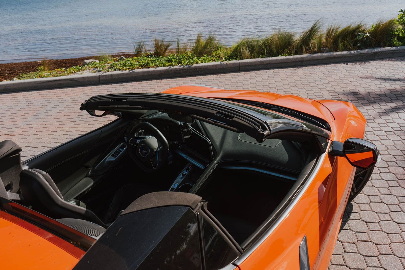 Interior of an orange Corvette C8 convertible with the top down
