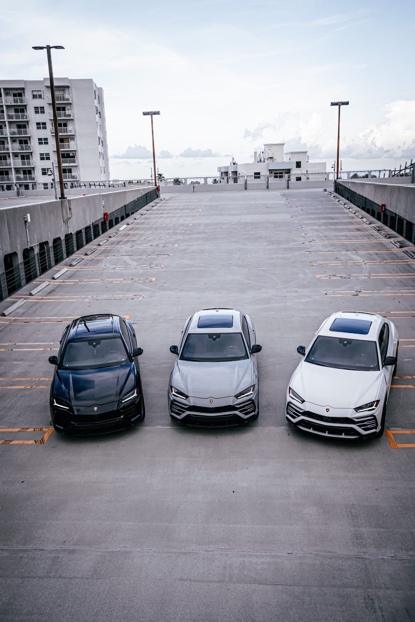 Black, grey and white Lamborghini Urus SUVs parked together in Miami