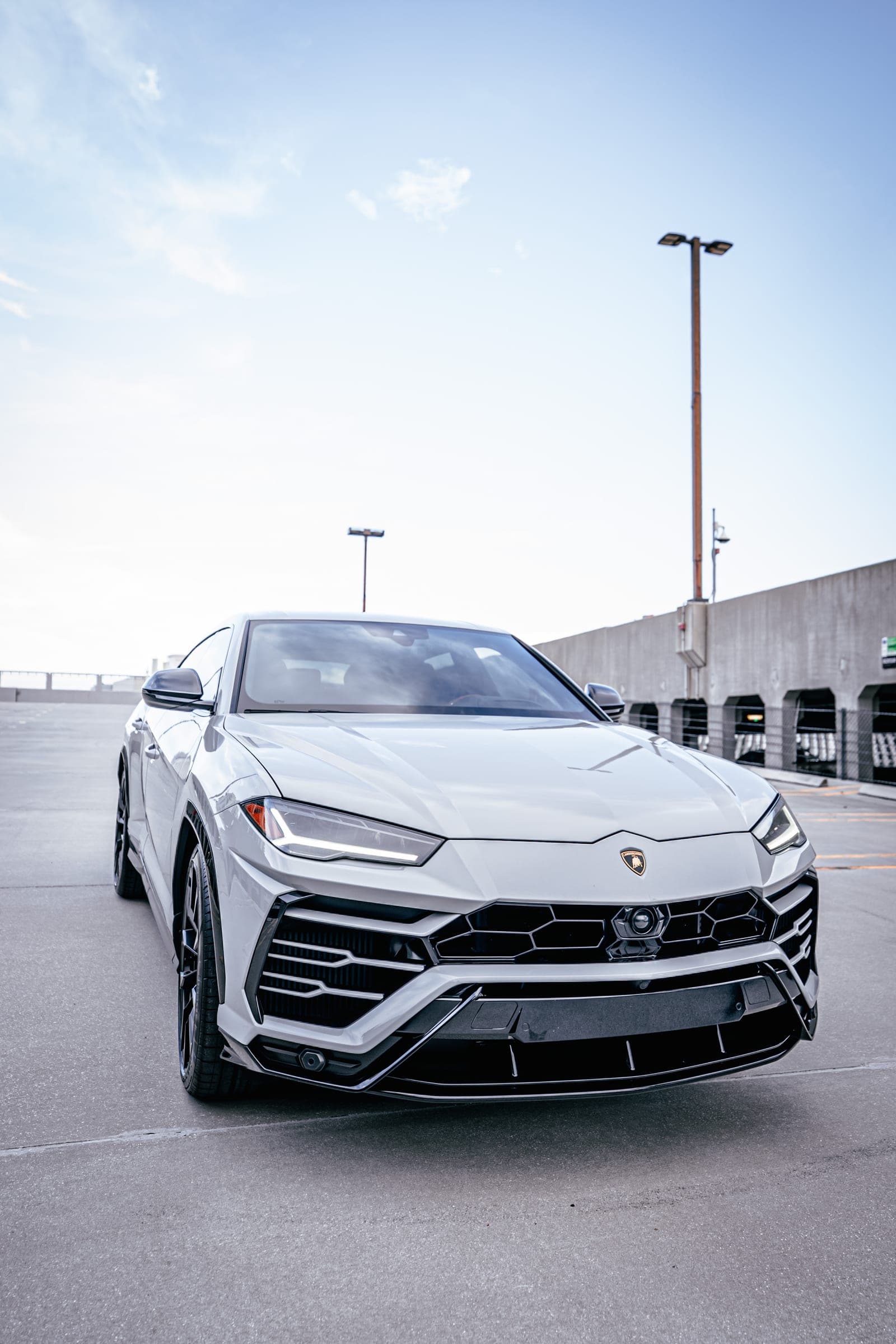 Front end and headlight detail of a grey Lamborghini Urus