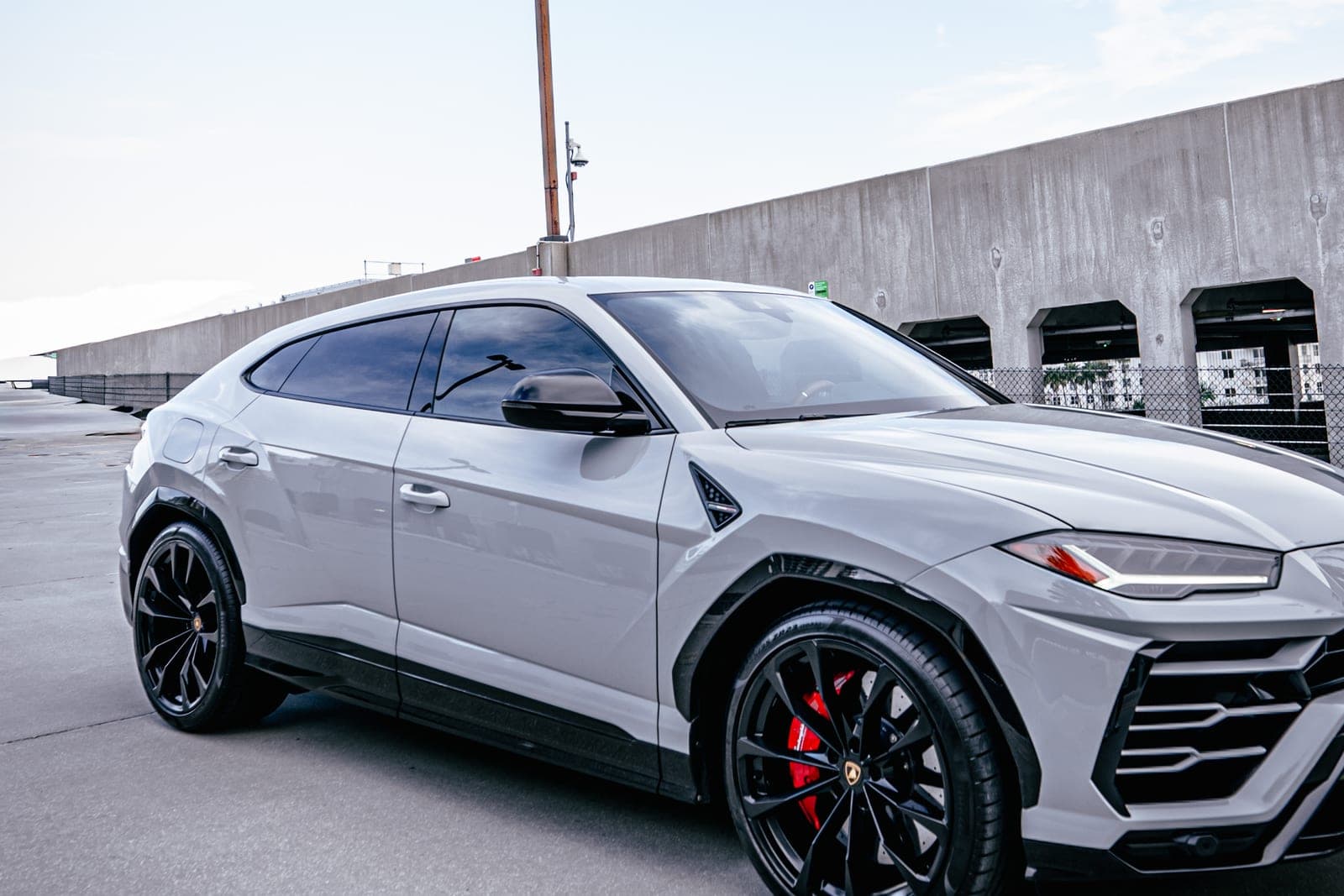 Grey Lamborghini Urus side profile with black wheels and red brake calipers