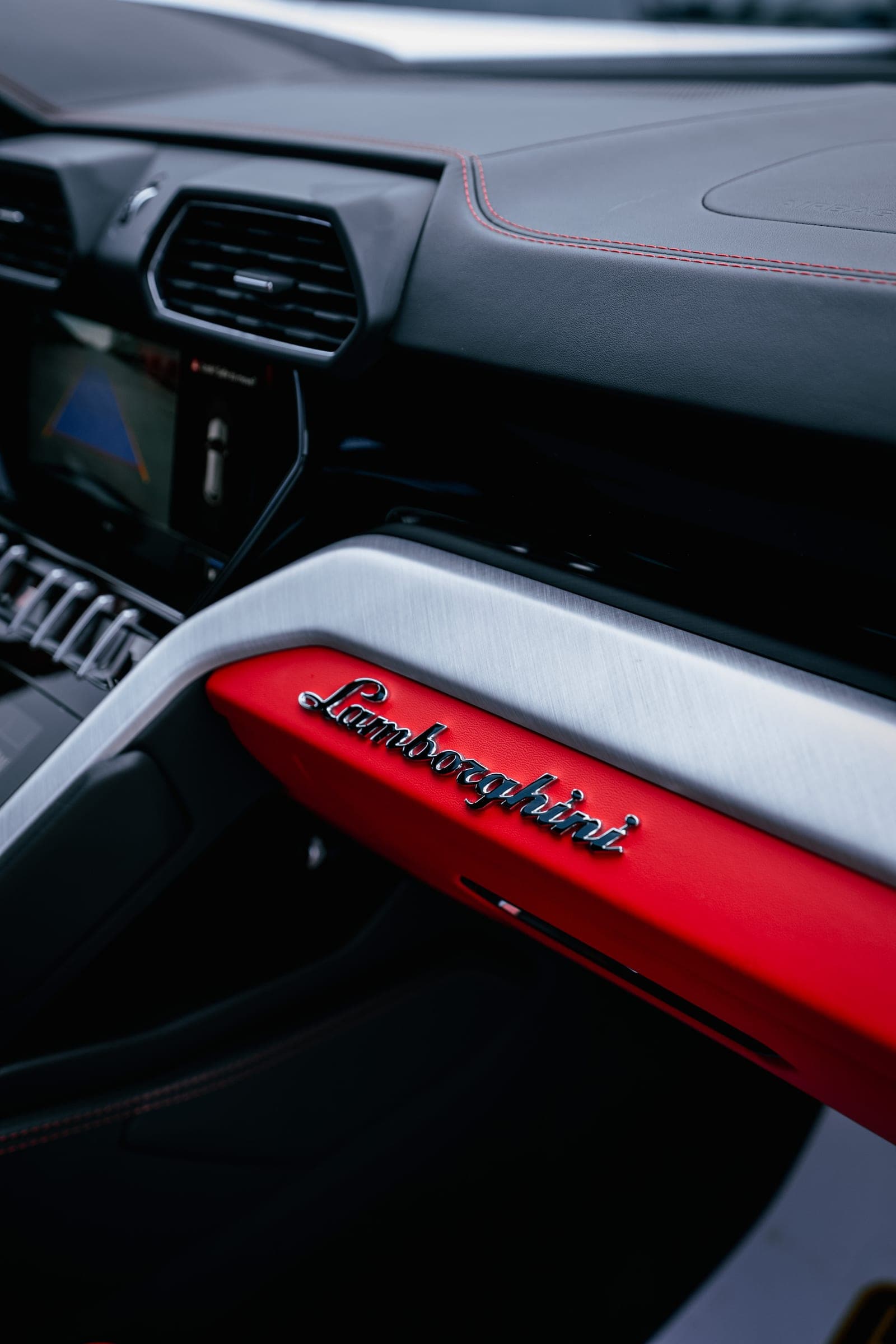 Lamborghini script on the red leather dashboard of a Urus