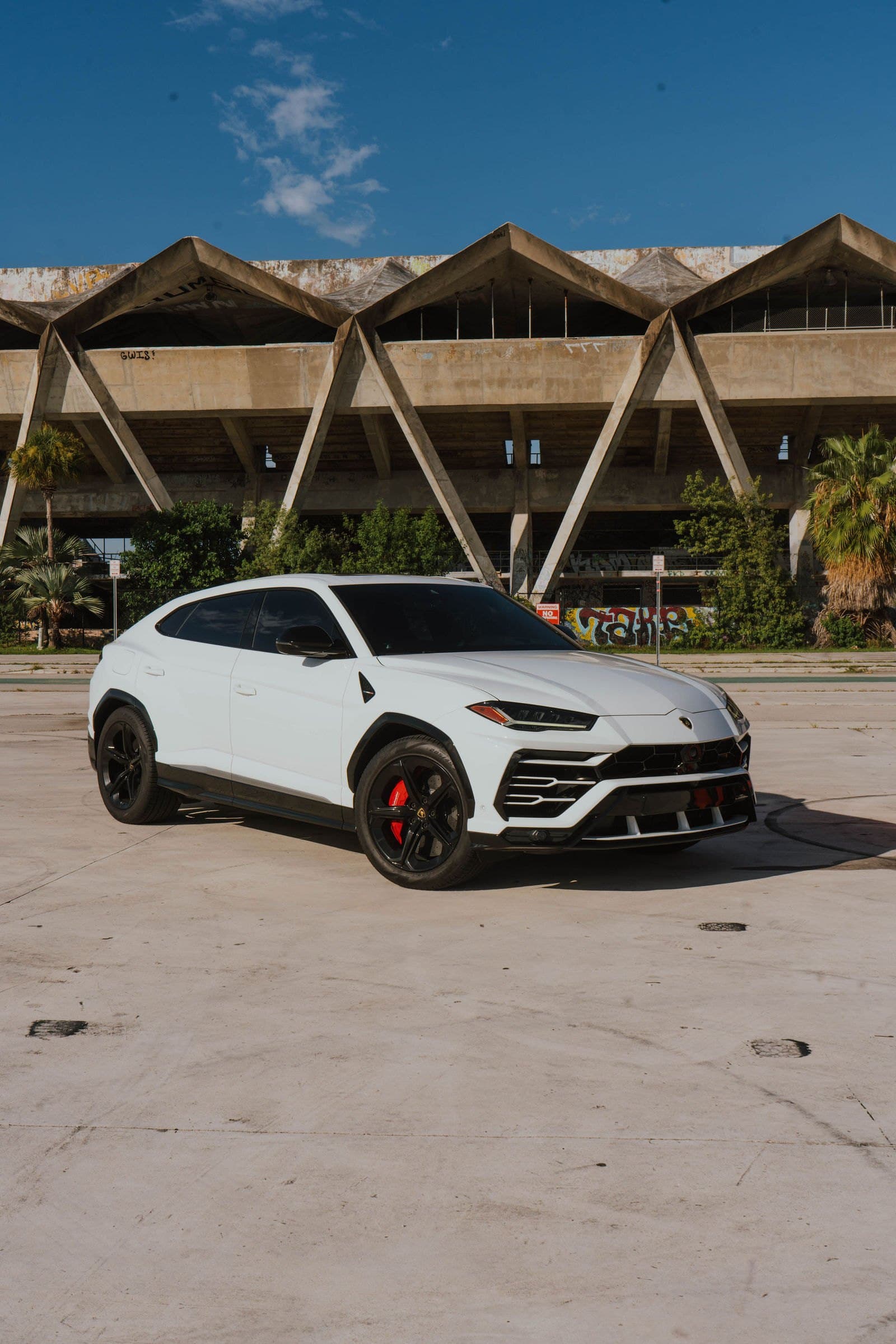 White Lamborghini Urus in front of the Miami Marine Stadium