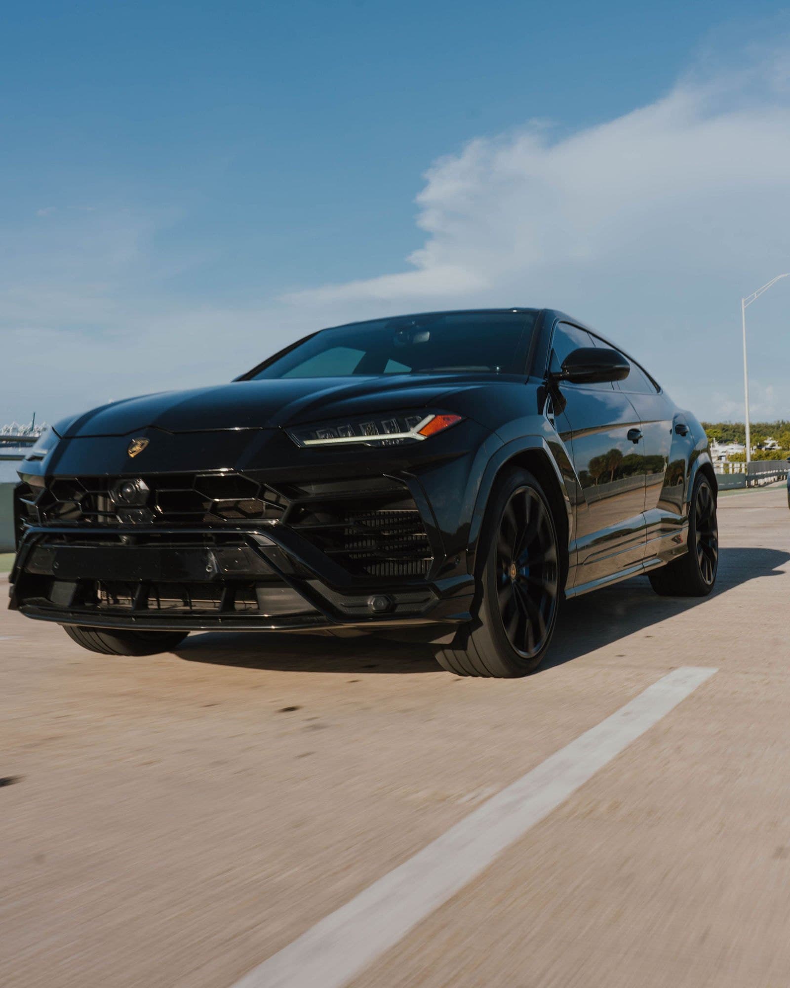 Black Lamborghini Urus rolling shot on a Miami bridge
