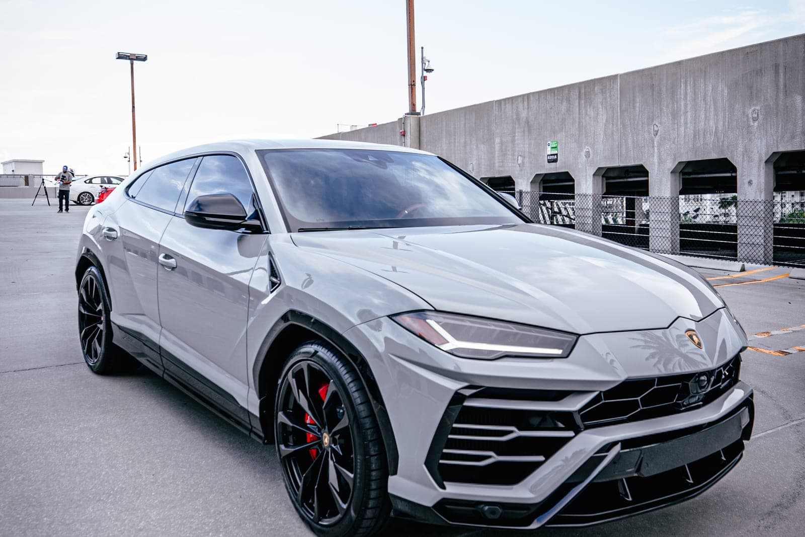 Grey Lamborghini Urus front three-quarter view on a Miami rooftop deck